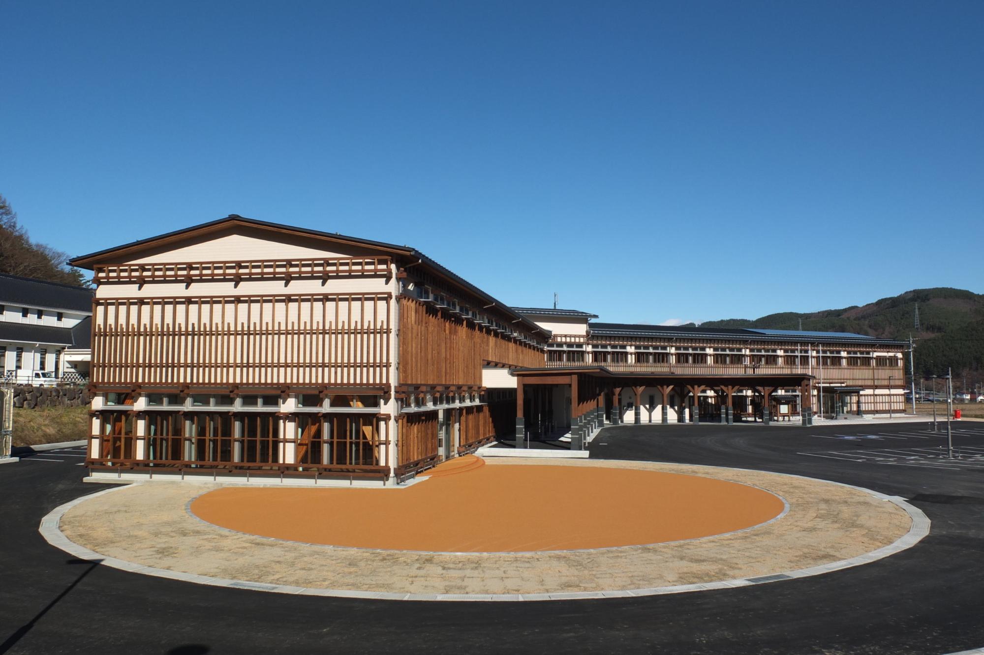 長和町産の唐松材地元の木材を使った「くの字」型配置の3階建ての建物で、宿場町の面影を感じさせる長和町役場庁舎の外観写真