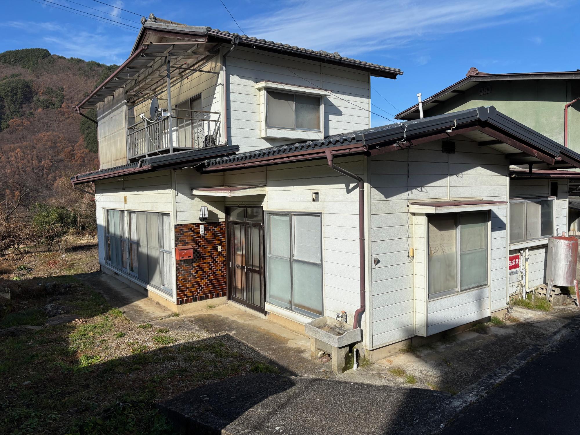 瓦屋根の白色外壁バルコニー付き2階建ての住宅の写真