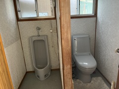 小便器と洋式トイレとの間を壁で仕切っている様子の写真