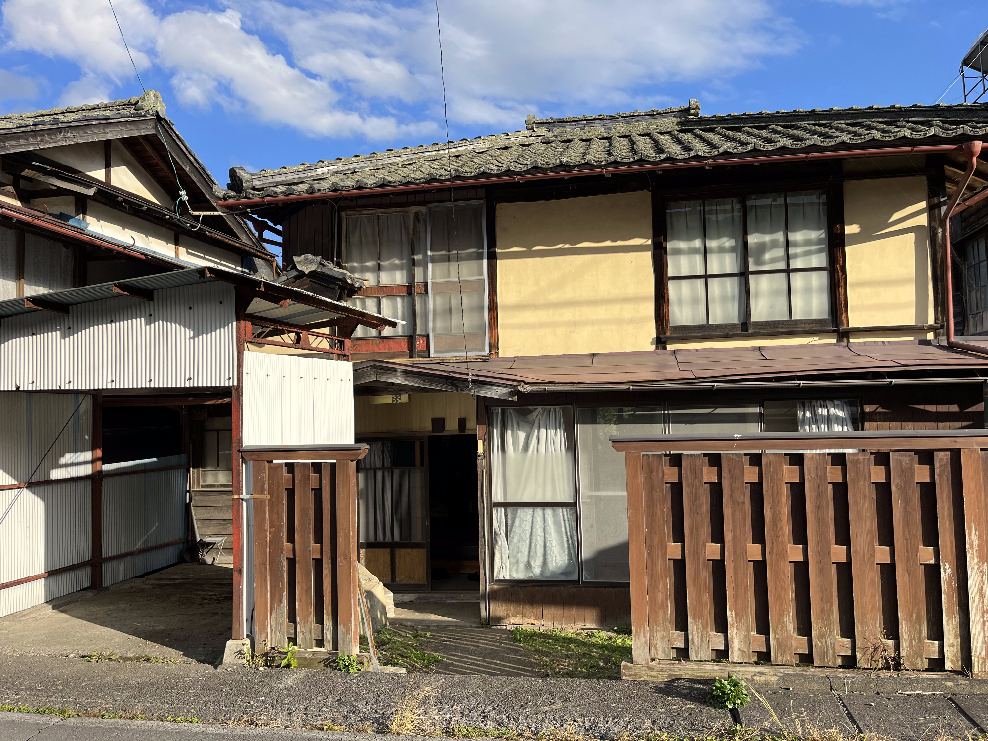 左側に車庫がある日本瓦屋根の木造2階建て建物の外観写真