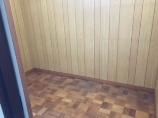 茶色い壁、板の間の納戸の内観写真