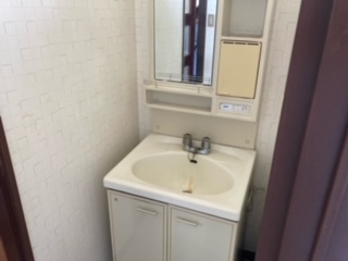 中央奥に、鏡付き収納ボックスがある洗面台の写真