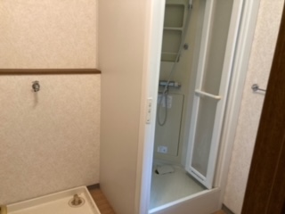 右側奥にシャワールーム、左側手前に洗濯機置き防水パン、左側奥に蛇口がある、シャワールームの写真