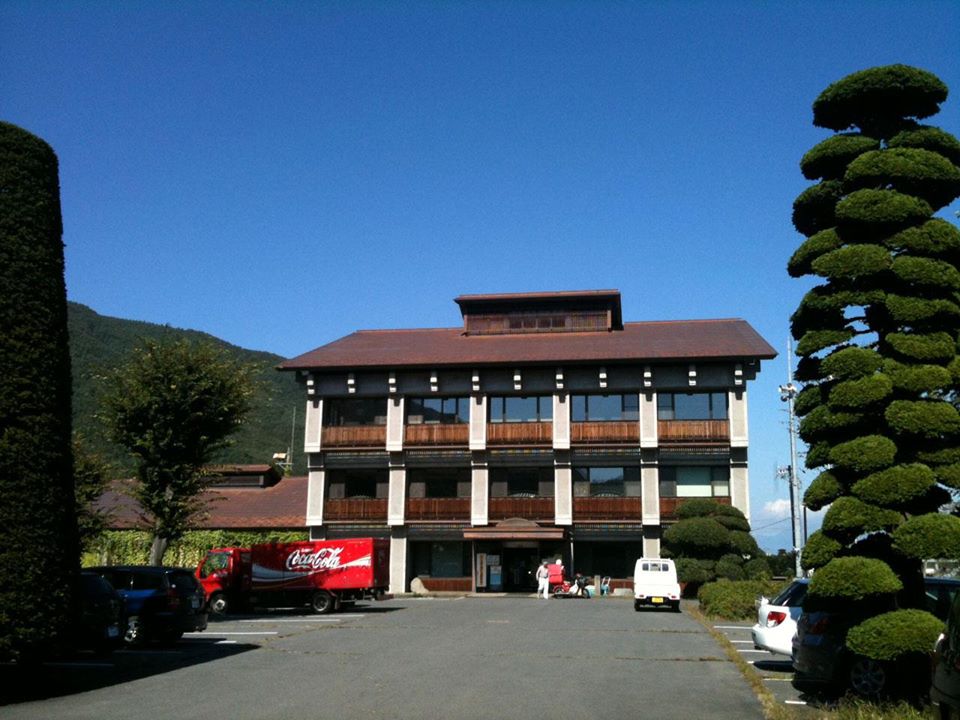 茶色の屋根をした3階建ての建物で、正面には広い駐車場が設置されている長和町役場和田庁舎の外観写真