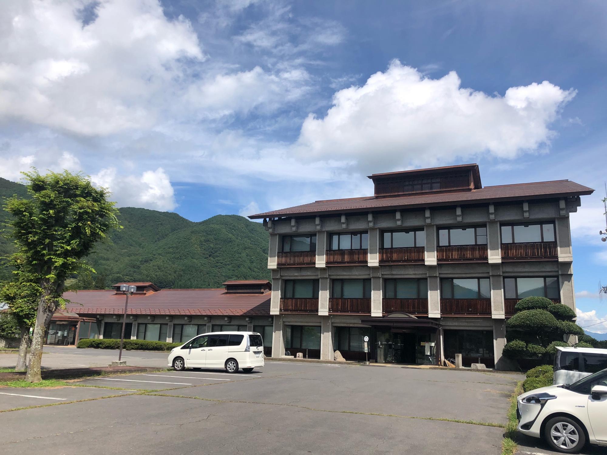 広々とした駐車場があり、3階建ての国保長和町和田歯科診療所の外観写真